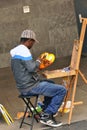 An artist paints the Cologne Cathedral.