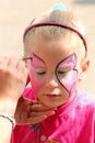 Artist paints on face of little girl Royalty Free Stock Photo