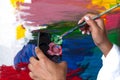 Artist paints a picture of oil paint brush in hand with palette closeup Royalty Free Stock Photo