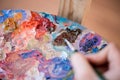 Artist paints a picture of oil paint brush in hand with palette closeup Royalty Free Stock Photo