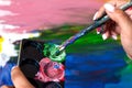 Artist paints a picture of oil paint brush in hand with palette closeup Royalty Free Stock Photo