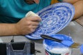 Artist paints unfired pottery in Avanos