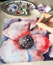 The artist paints a watercolor poppy flower. Image palette, sheet with a picture, brushes, paint, selective focus Royalty Free Stock Photo