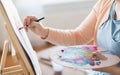 Artist with palette and brush painting at studio Royalty Free Stock Photo