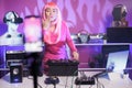 Artist with pink hair playing techno song at professional turntables while recording music process Royalty Free Stock Photo