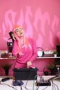 Artist with pink hair standing at dj table performing electronic song using professional turntables Royalty Free Stock Photo