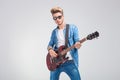 artist playing guitar in studio background while wearing sunglasses Royalty Free Stock Photo