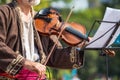 The artist plays the violin, the notes in front of him