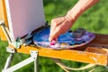 The artist`s hand, which squeezes the oil paint from the tube in Royalty Free Stock Photo