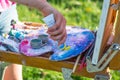 The artist`s hand, which squeezes the oil paint from the tube in Royalty Free Stock Photo