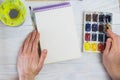 The artist`s hands, paint palette brushes, different colors. The girl is drawing. The artist`s tools for real art and inspiratio Royalty Free Stock Photo