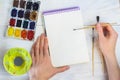 The artist`s hands, paint palette brushes, different colors. The girl is drawing. The artist`s tools for real art and inspiratio Royalty Free Stock Photo