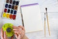 The artist`s hands, paint palette brushes, different colors. The girl is drawing. The artist`s tools for real art and inspiratio Royalty Free Stock Photo