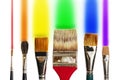 Artist`s paintbrushes against a white background and rainbow colored brush strokes