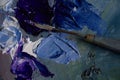 Artist`s palette with blue and red oil paints with a bristle brush and a palette knife Royalty Free Stock Photo