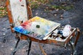 The artist`s palette with brushes in a box is on the street, ready to work. Selective focus