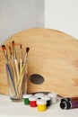 Artist\'s palette, colorful paints and brushes on white wooden table