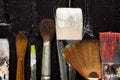 Artist`s tools, brushes in paint are in a row on a black wooden background. Royalty Free Stock Photo