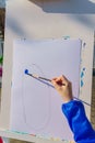 Artist`s work place. A kid paints with blue gouache a picture. Open air workshop Royalty Free Stock Photo