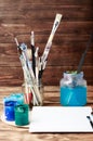 Artist`s workshop. Top view of paintbrushes palette and acrylic paints with white canvas. Set of brushes and oil paints. Art pictu