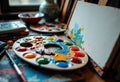 Artistic workspace with a colorful paint palette, brushes, and an abstract Royalty Free Stock Photo