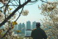 artist sketching a city view framed by flowering branches