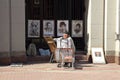 Artist on a spring day on the pedestrian Arbat street in Moscow