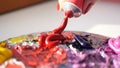 Artist squeezes from the tube to the palette purple oily paint , HD. Royalty Free Stock Photo