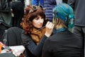 Artist in steampunk style creating makeup for young woman at the festival `Bright people` on City Day on Neglinaya street in Mosco