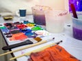 Artist tools, paint brushes, white bucket of water and acrylic colour artist palette in art studio Royalty Free Stock Photo