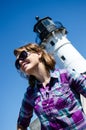 Artistic angle of a woman standing and smiling in front of Canal Lighthouse in Duluth on sunny day