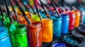 Artistic Array of Paintbrushes Resting in Jars of Blue Green Red and Orange Paint a Vivid Display of Art Tools