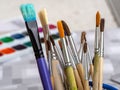 Artistic brushes close up. Watercolor paints in the background. Royalty Free Stock Photo