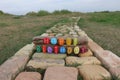 Happy Birthday text with colored stones on wood over a bricks road
