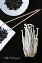 Artistic composition of Asian Food Products - Enoki mushrooms and dry seaweed on a black background