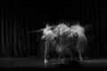 An artistic dancer in a theater shot with a slow shutter speed in order to achieve the desired motion blur Royalty Free Stock Photo