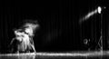 An artistic dancer in a theater shot with a slow shutter speed in order to achieve the desired motion blur Royalty Free Stock Photo