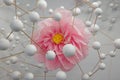 Artistic Depiction of a Pink Flower in Crepe Paper surrounded by a Structure of White Spheres connected Together Royalty Free Stock Photo