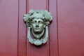 Artistic detail in elaborate knocker on red door of home