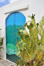 artistic door painted in sea colors, door in Ostuni, turquoise-blue door in a white wall