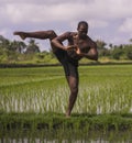 Young attractive contemporary ballet dancer and choreographer , a black African American man dancing and posing on tropical rice Royalty Free Stock Photo