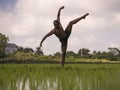 Young attractive contemporary ballet dancer and choreographer , a black African American man dancing and posing on tropical rice Royalty Free Stock Photo