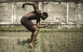 Young attractive contemporary ballet dancer and choreographer , a black afro American man dancing and posing on tropical rice Royalty Free Stock Photo