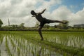 Young attractive contemporary ballet dancer and choreographer , a black afro American man dancing and posing on tropical rice Royalty Free Stock Photo