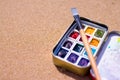 Artistic equipment: paint brushes, watercolors paintings on sand background at sunny summer day - creation, drawing and freedom co Royalty Free Stock Photo