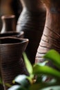 Artistic focus on textured vases with blurred greenery. - AI Generated