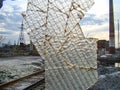 Artistic glass installation forms a large, possibly architectural structure in an industrial or abandoned setting Royalty Free Stock Photo