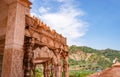 artistic hand carved red stone jain temple with bright blue sky at morning from unique angle