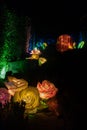 Artistic handmade flower glowing at night with neon lights inside on a night garden