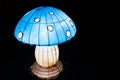 Artistic handmade mushroom glowing at night with neon lights inside on a night garden